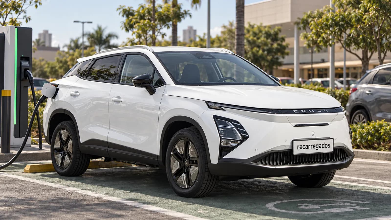 Omoda E5 no Brasil: review, preço, autonomia e vale a pena? Omoda E5 branco em eletroposto de recarga rápida em São Paulo, imagem gerada com IA a partir de foto real