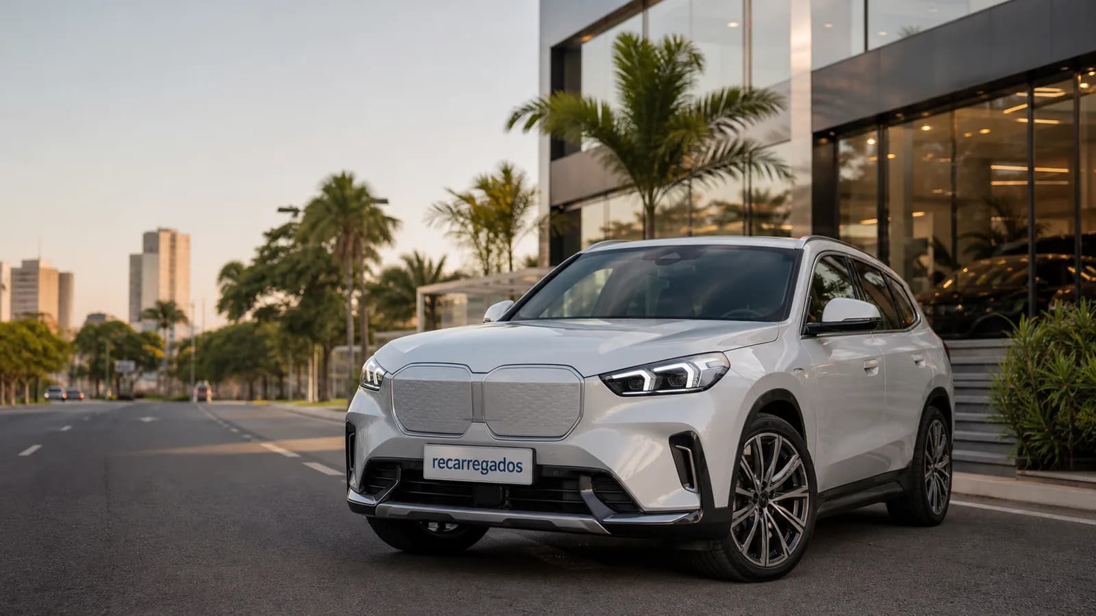 SUV elétrico BMW iX1 em avenida brasileira com placa recarregados em destaque