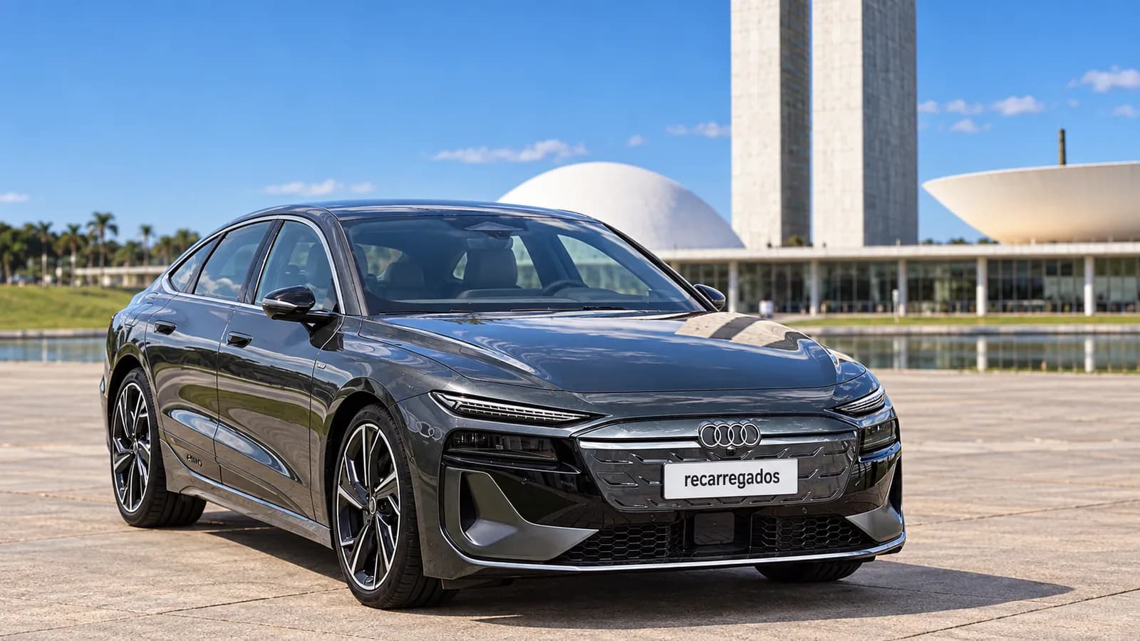 Audi A6 Sportback e-tron cinza-escuro diante da arquitetura modernista de Brasília, imagem gerada com IA a partir de foto real