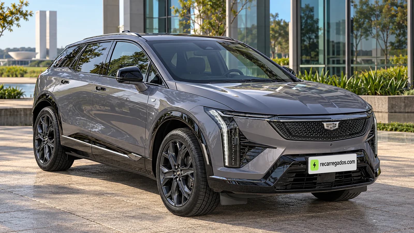 Cadillac Optiq cinza-escuro diante de prédio moderno em Brasília, imagem gerada com IA a partir de foto real